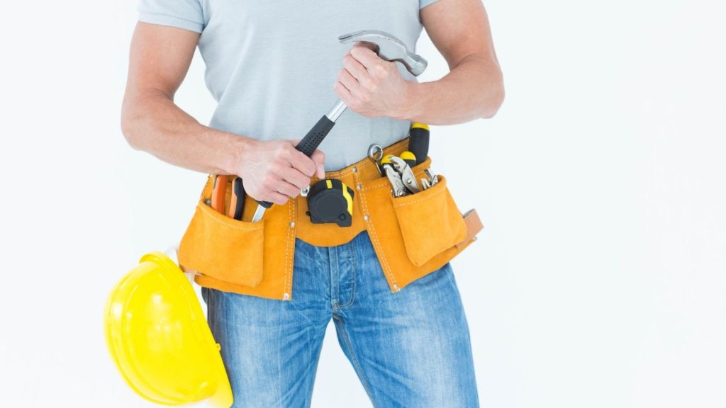 man wearing a tool belt and holding a hammer