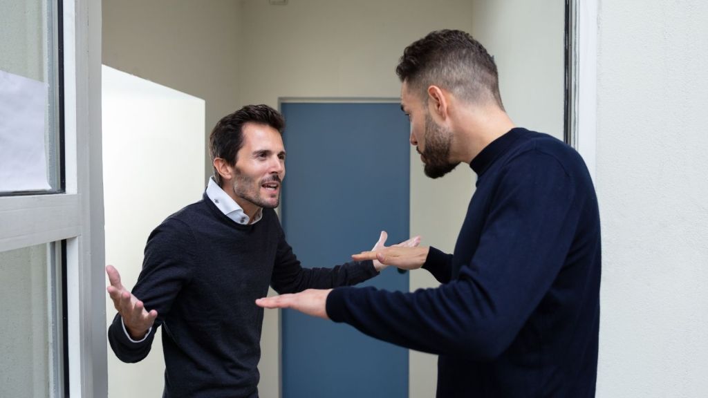 two men arguing in a doorway