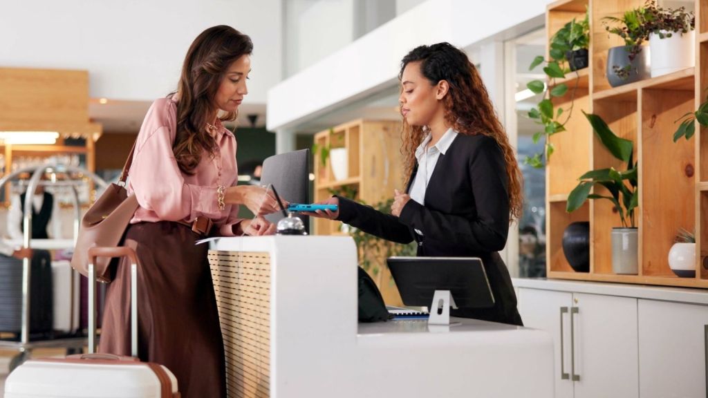 woman talking to front desk worker at a hotel