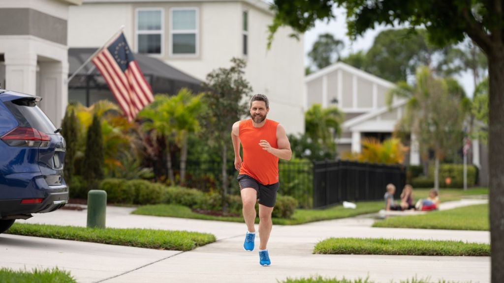 man running on neighborhood sidewalk