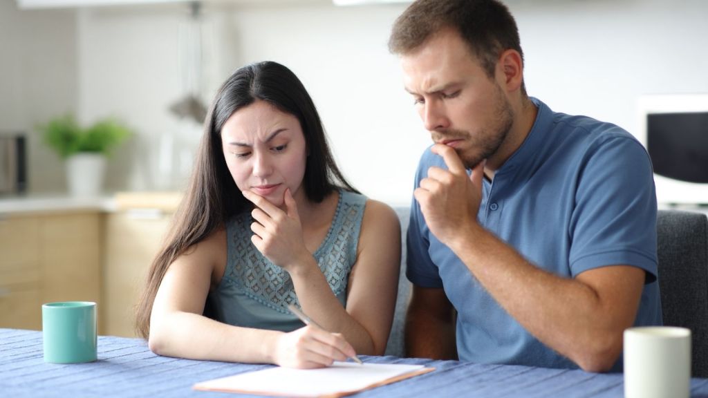 couple looks worried while reading a form