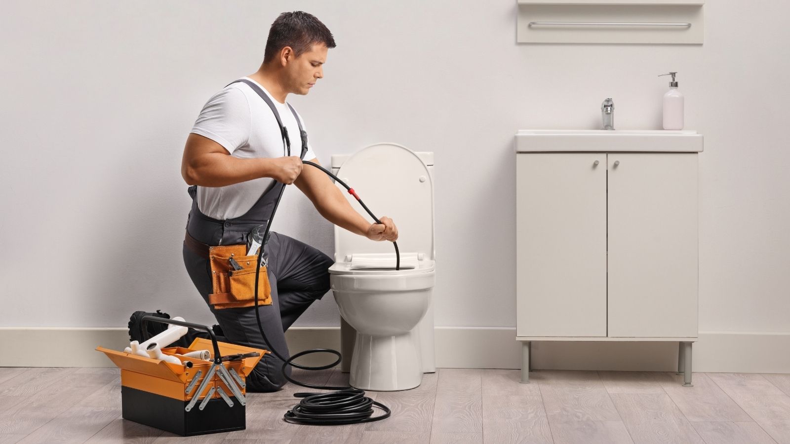 plumber using a snake to unclog a drain
