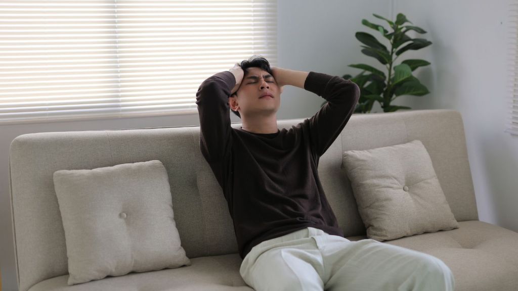 stressed out young man sitting on a couch