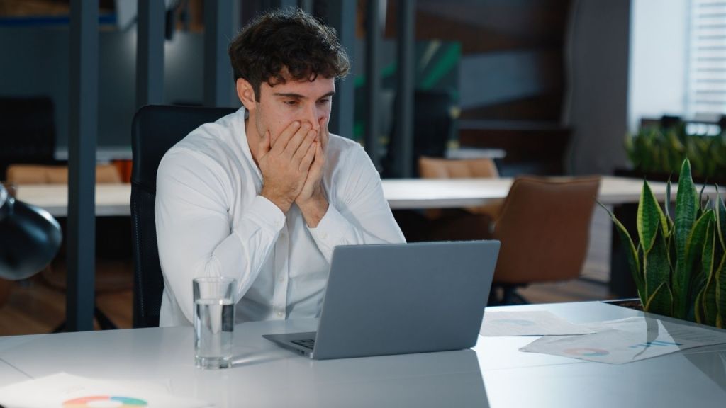 upset man looking at a computer