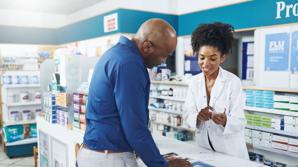 man picking up prescription at pharmacy