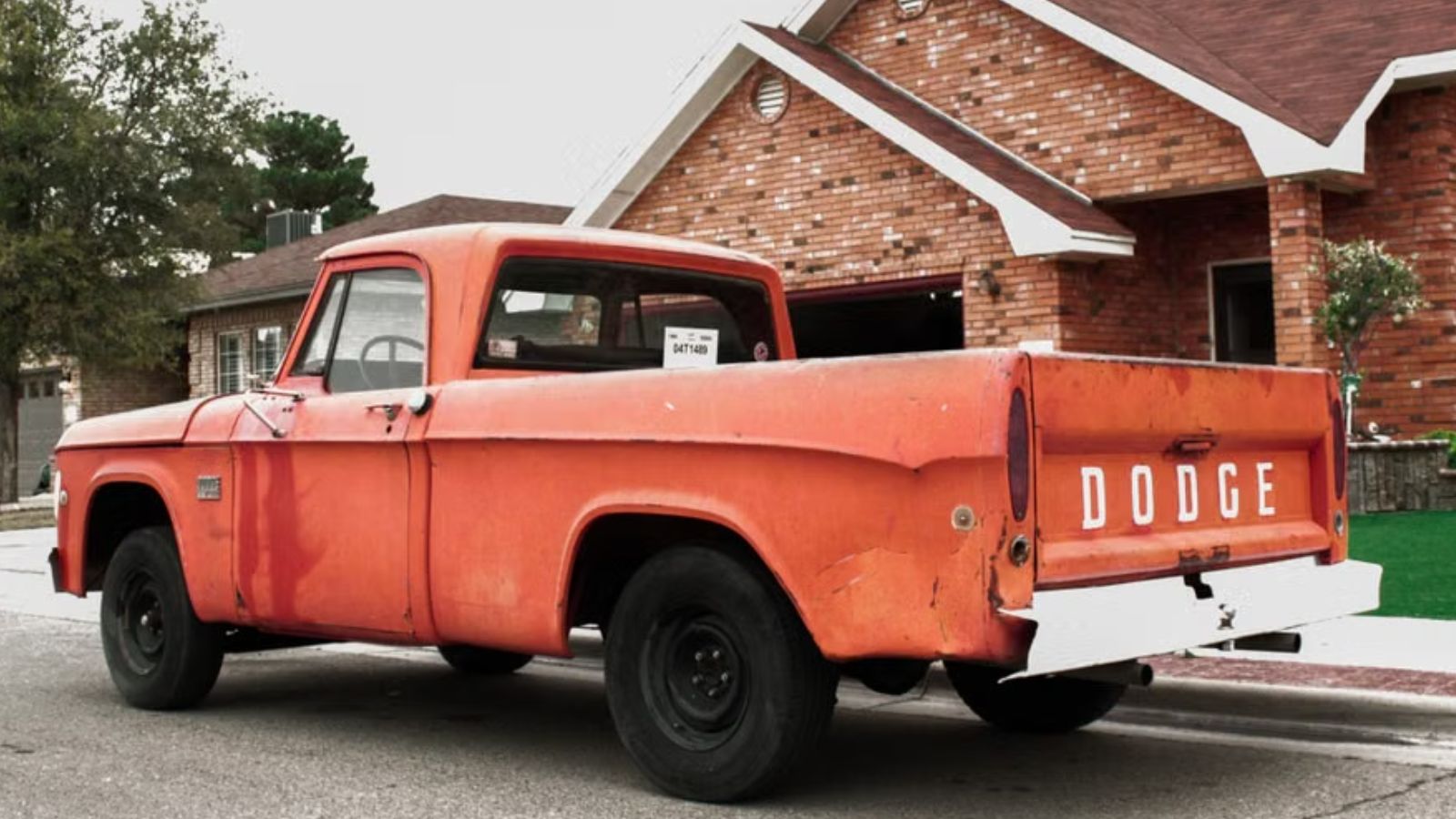 Woman Was Stressed With How Her Neighbors Park Their Vehicles Near Her Driveway, But Shes Not Sure Talking To Them Will Work A red Dodge pick up truck parked on the street in front of a huge brick house