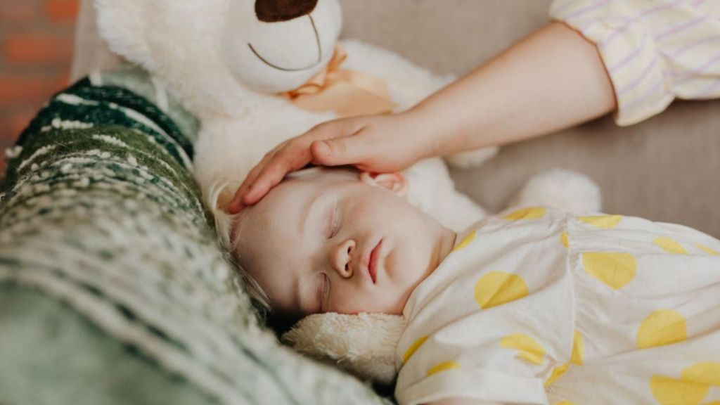 Woman holding the baby's head while sleeping