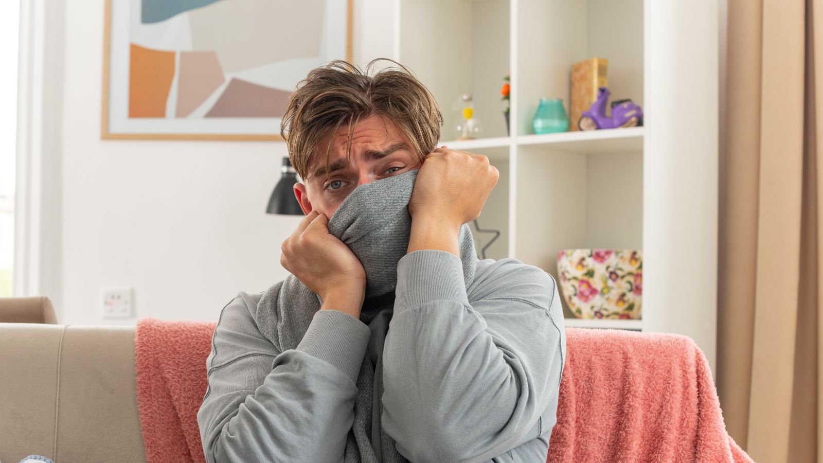 His Roommate Kept Dissected Animals Near the Food—So He Took Matters Into His Own Hands Man covering his nose while sitting on the couch at living room