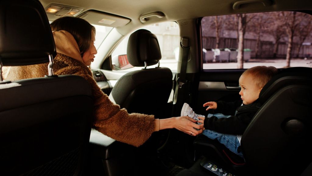 Mother and child in baby seat inside the car