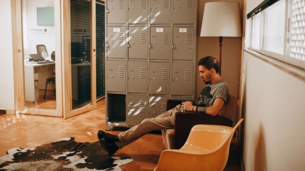 Man using his phone while sitting in the waiting area of an office