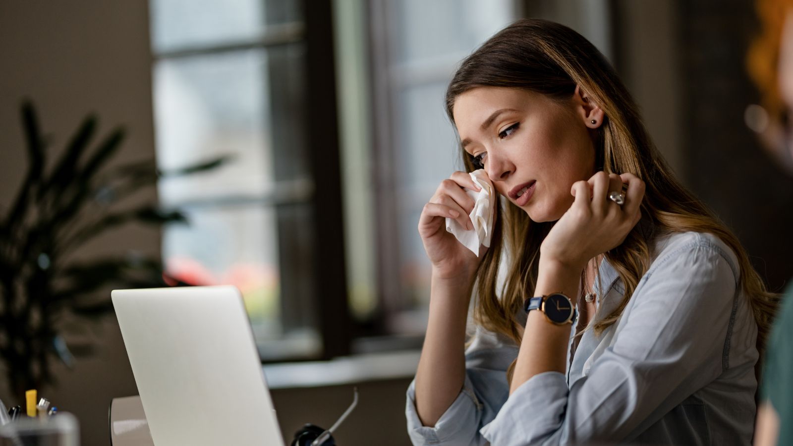A Recent Grad Walked Out on Her First Day After Overwhelming Anxiety and Missing Her Dog Young woman quietly weeping in front of her laptop in the office