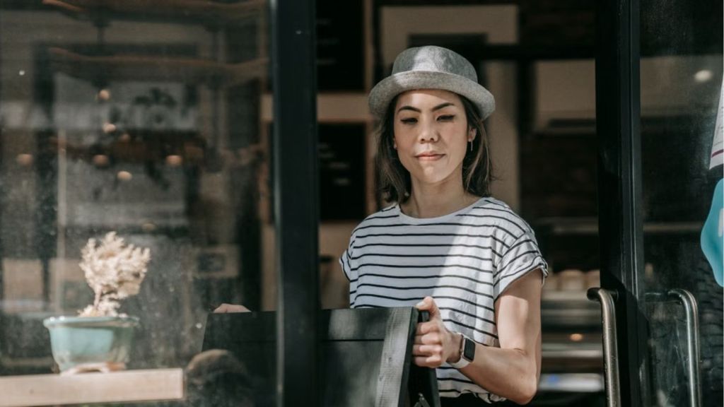 Woman working in a cafe and holding a menu board