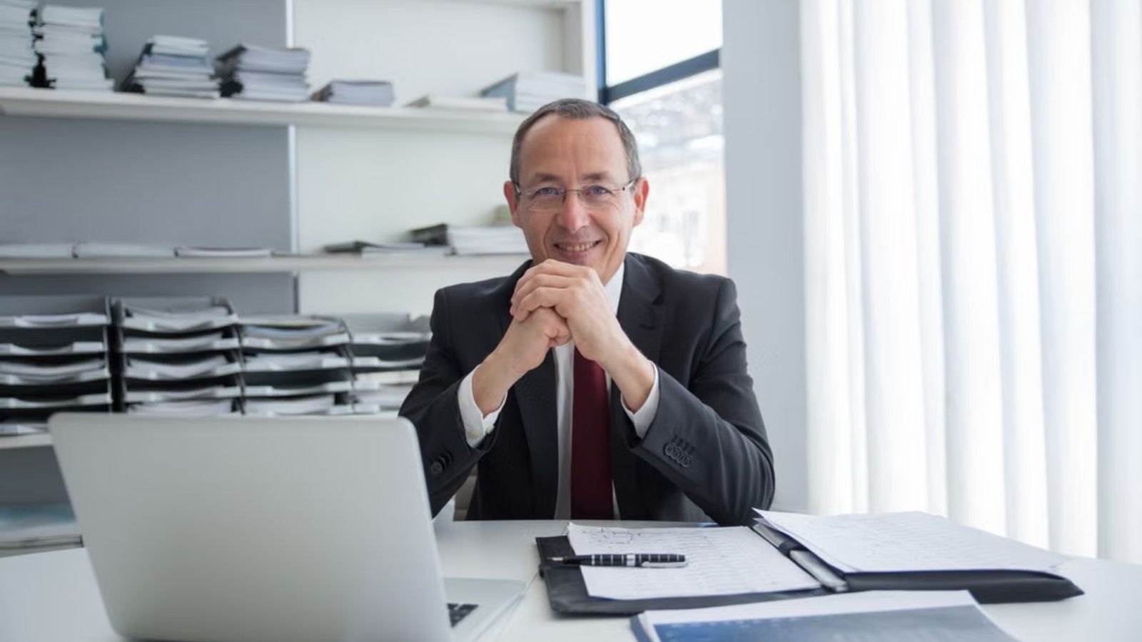He Discovered His CEO’s Salary and Bonuses—And Suddenly Started Questioning Workplace Fairness A company CEO smiling and feeling comfortable in his office