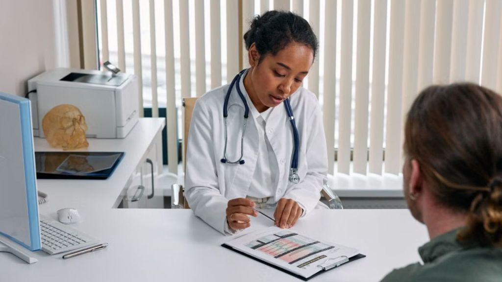 Doctor filling out a form while talking to a patient