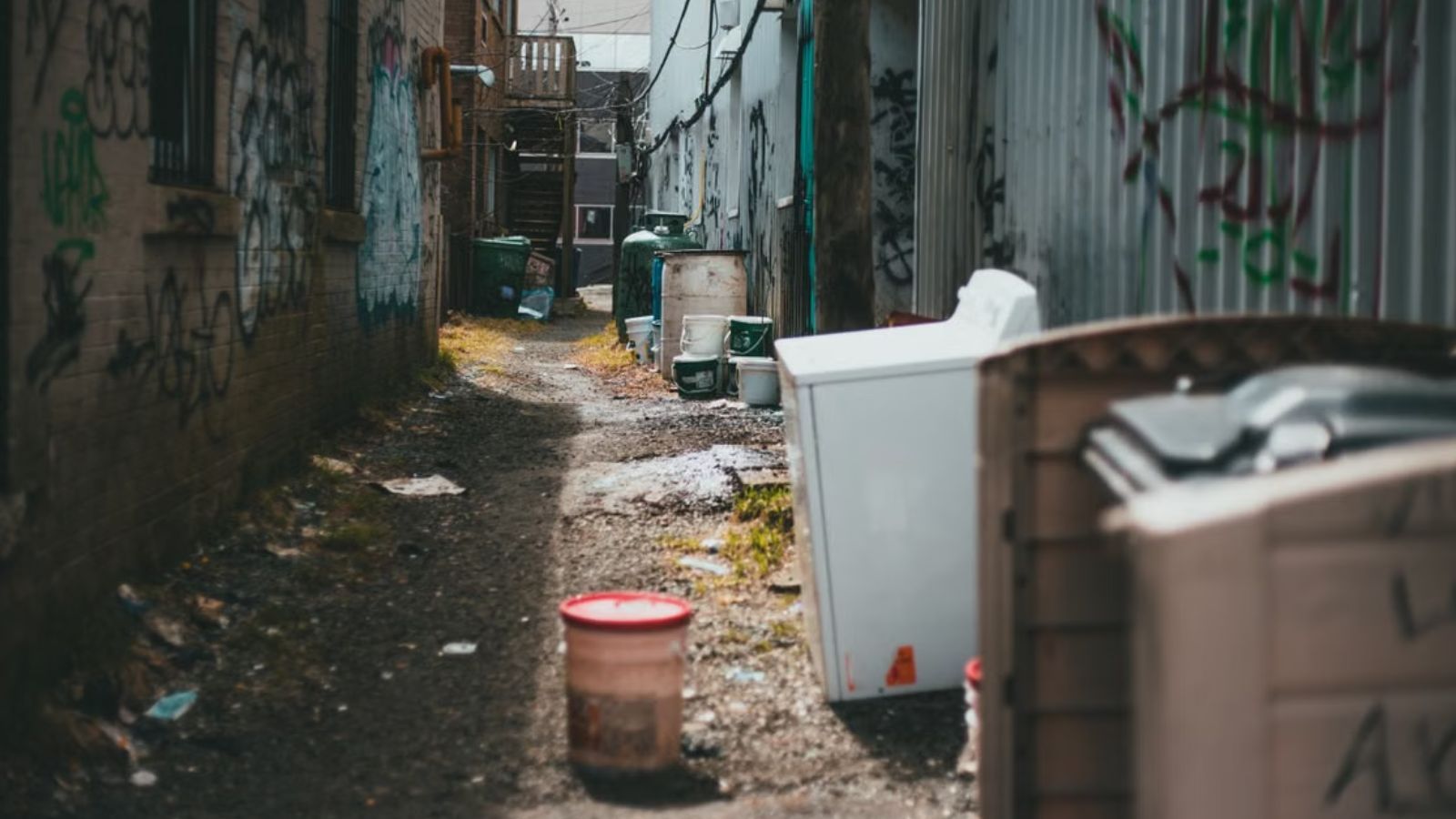 A messy yard with old appliance and trash