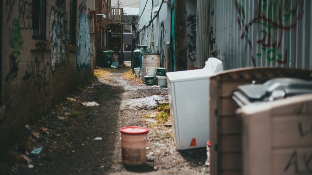 A messy yard with old appliance and trash
