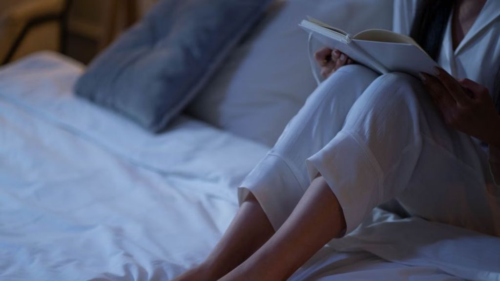 Woman reading a book inside a dark room