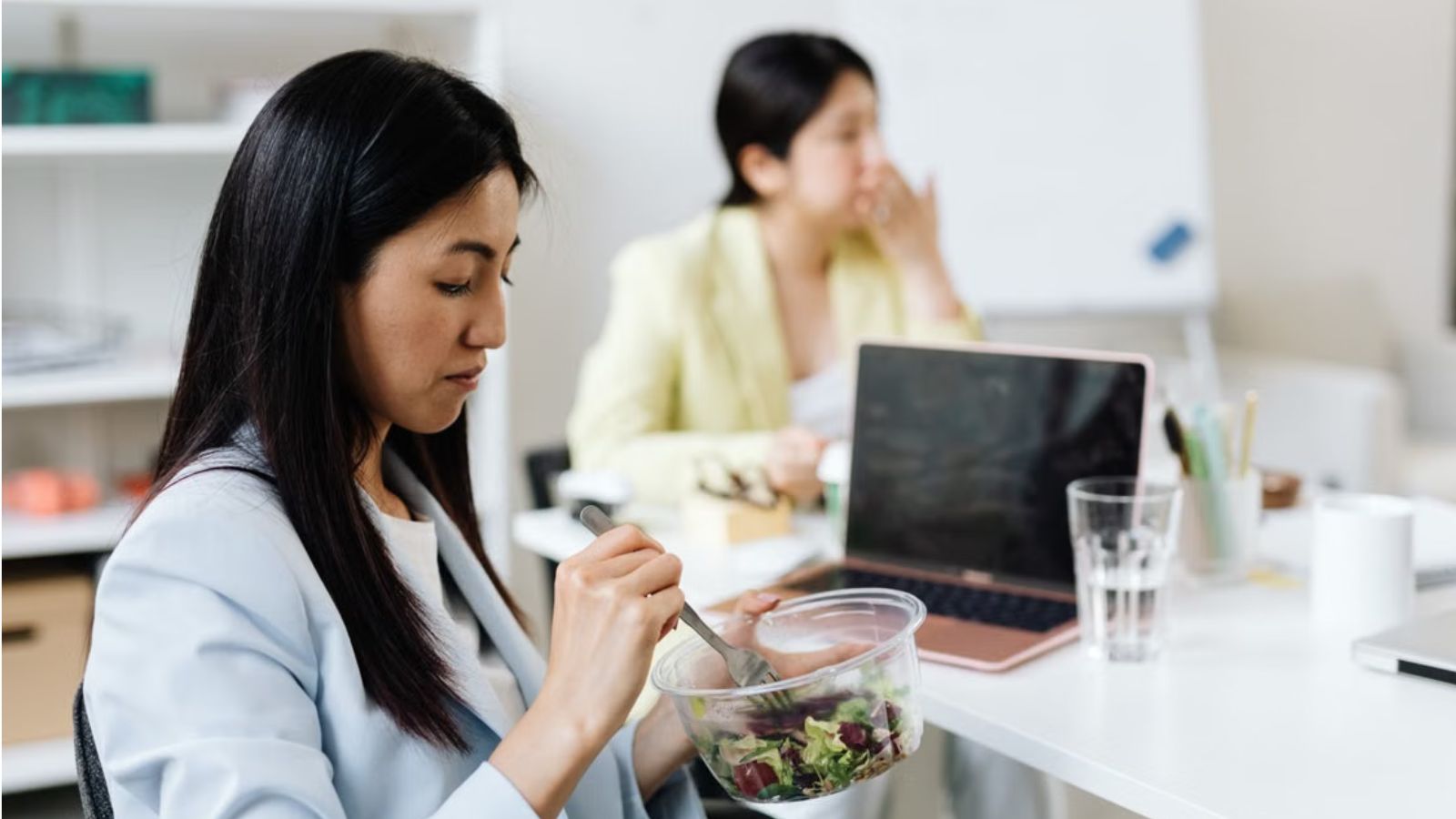Employees eating at their work station in the office