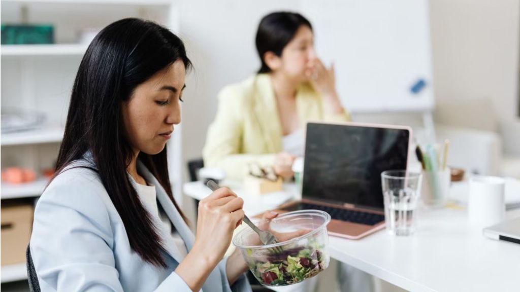 Employees eating at their work station in the office