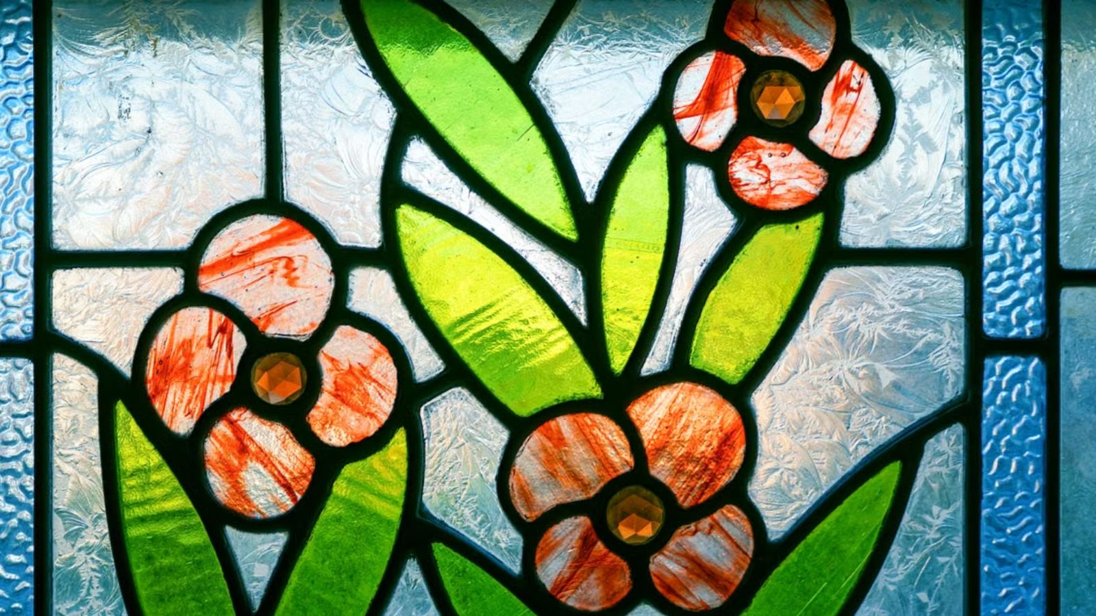 His Student Tried to Steal a Stained Glass Commission—Then Expected Him to Help Complete It Stained glass art featuring green leaves and red flowers