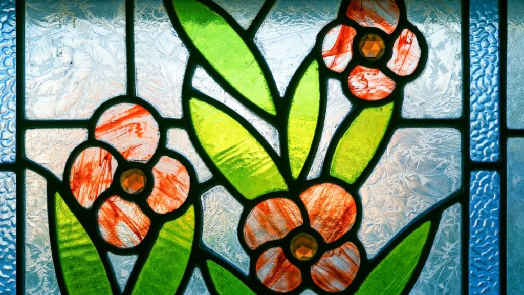 Stained glass art featuring green leaves and red flowers