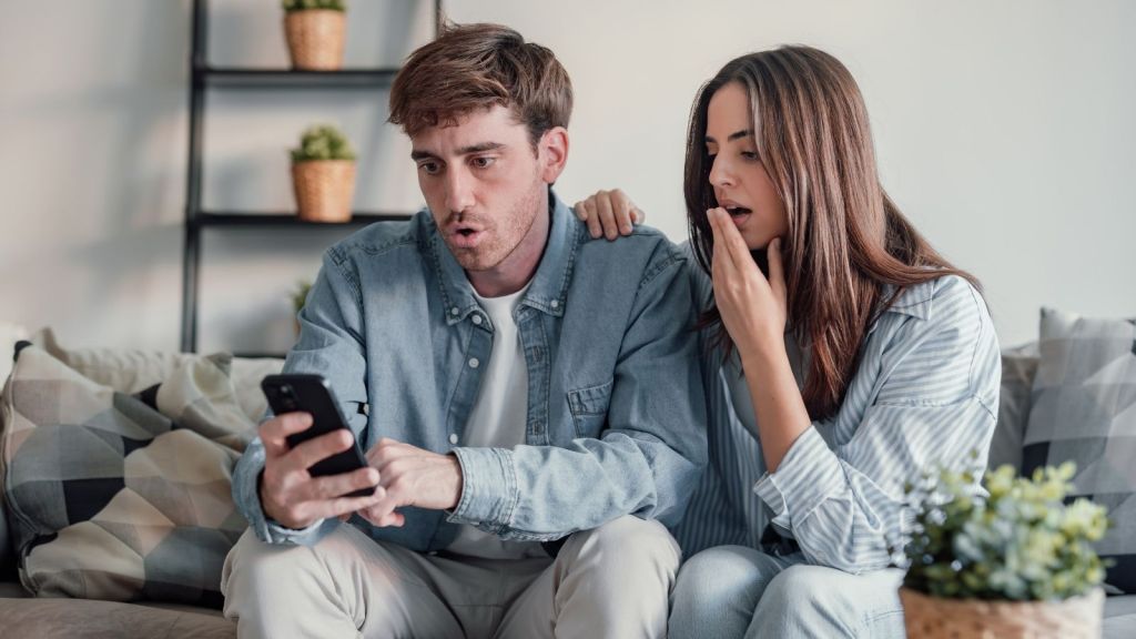 upset couple looking at a phone