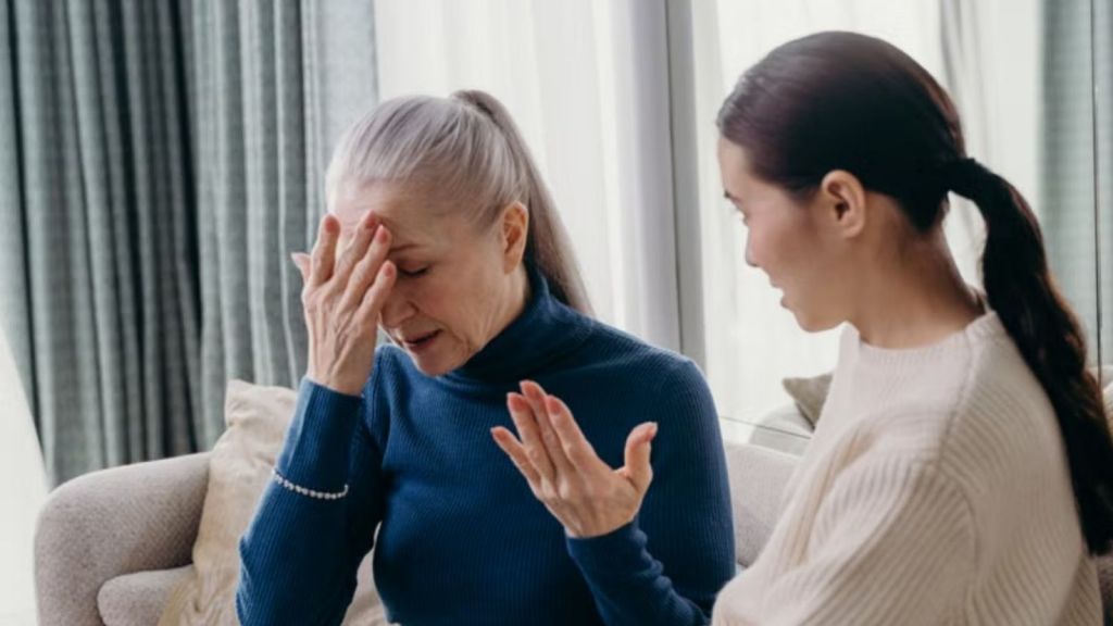 An older woman and a younger woman having an emotional conversation at home