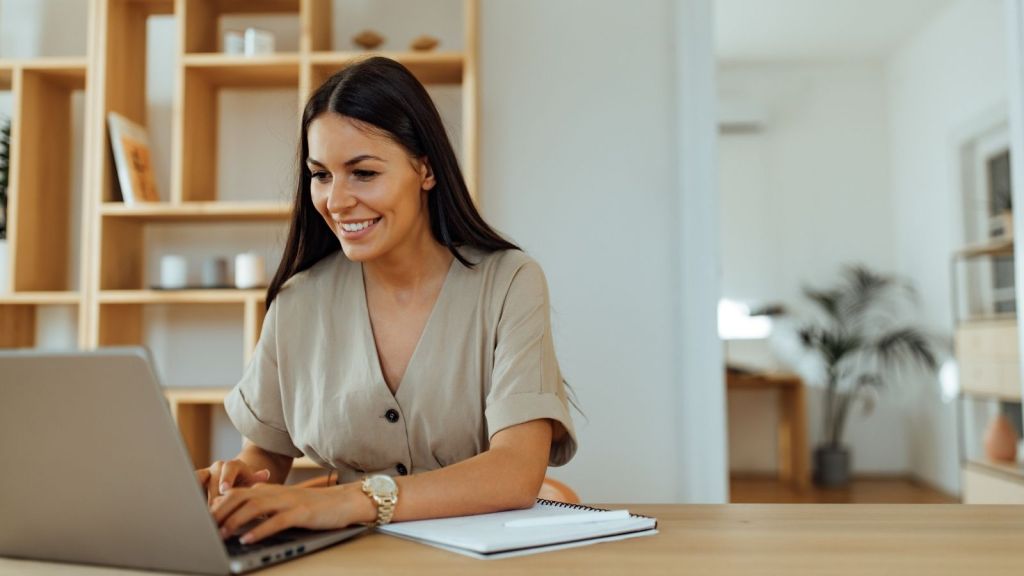 smiling woman looking at a computer at home