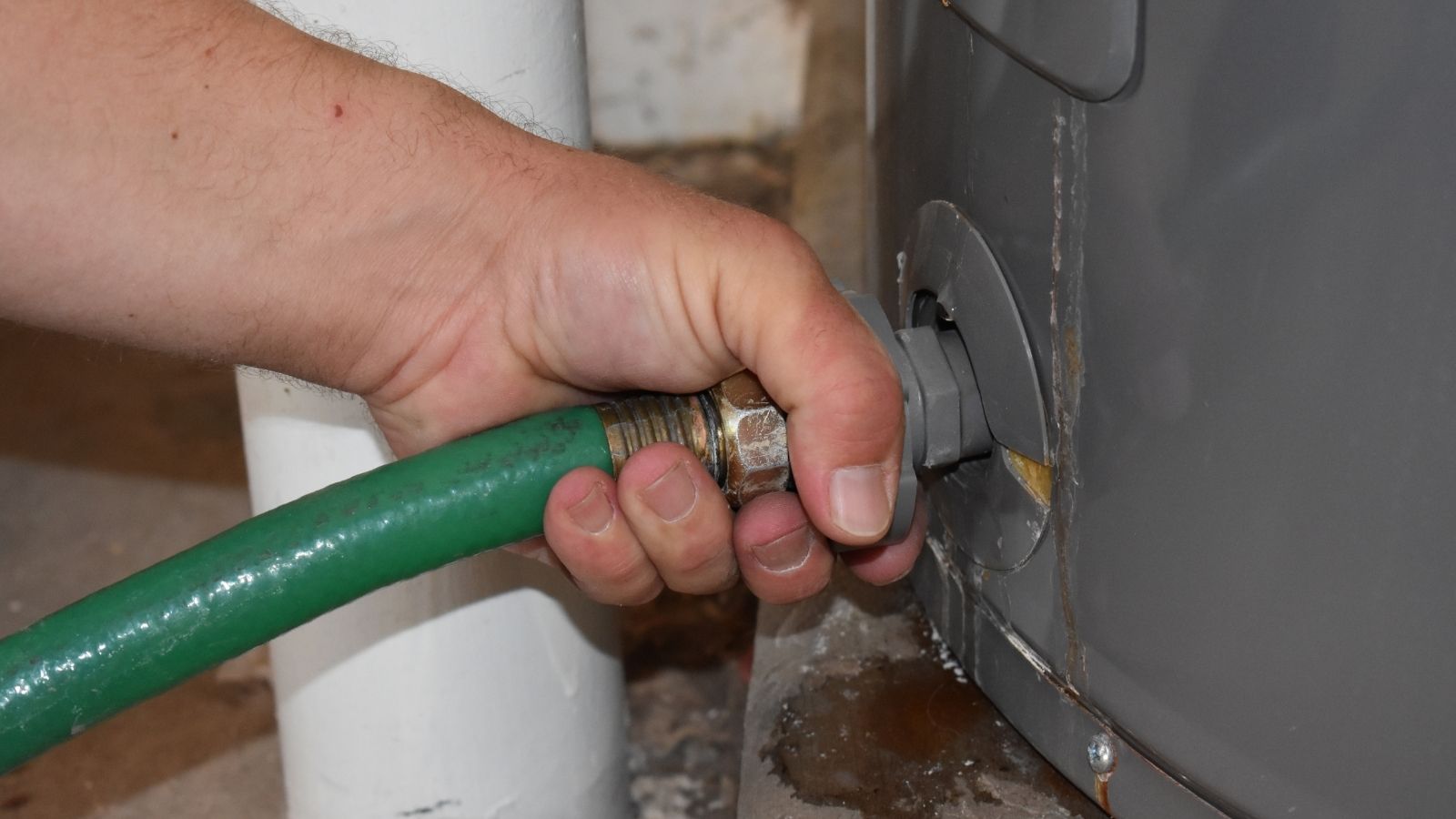 She Caught Her Neighbors Contractor Stealing Water From Her Spigot—And Called the Police Over It. man hooking up hose outside house