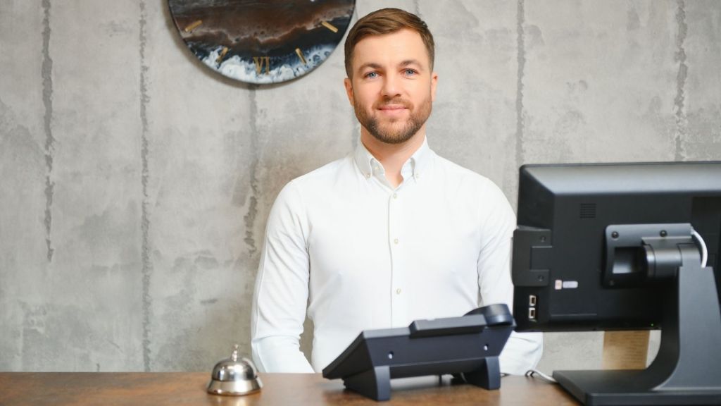 man working at hotel front desk