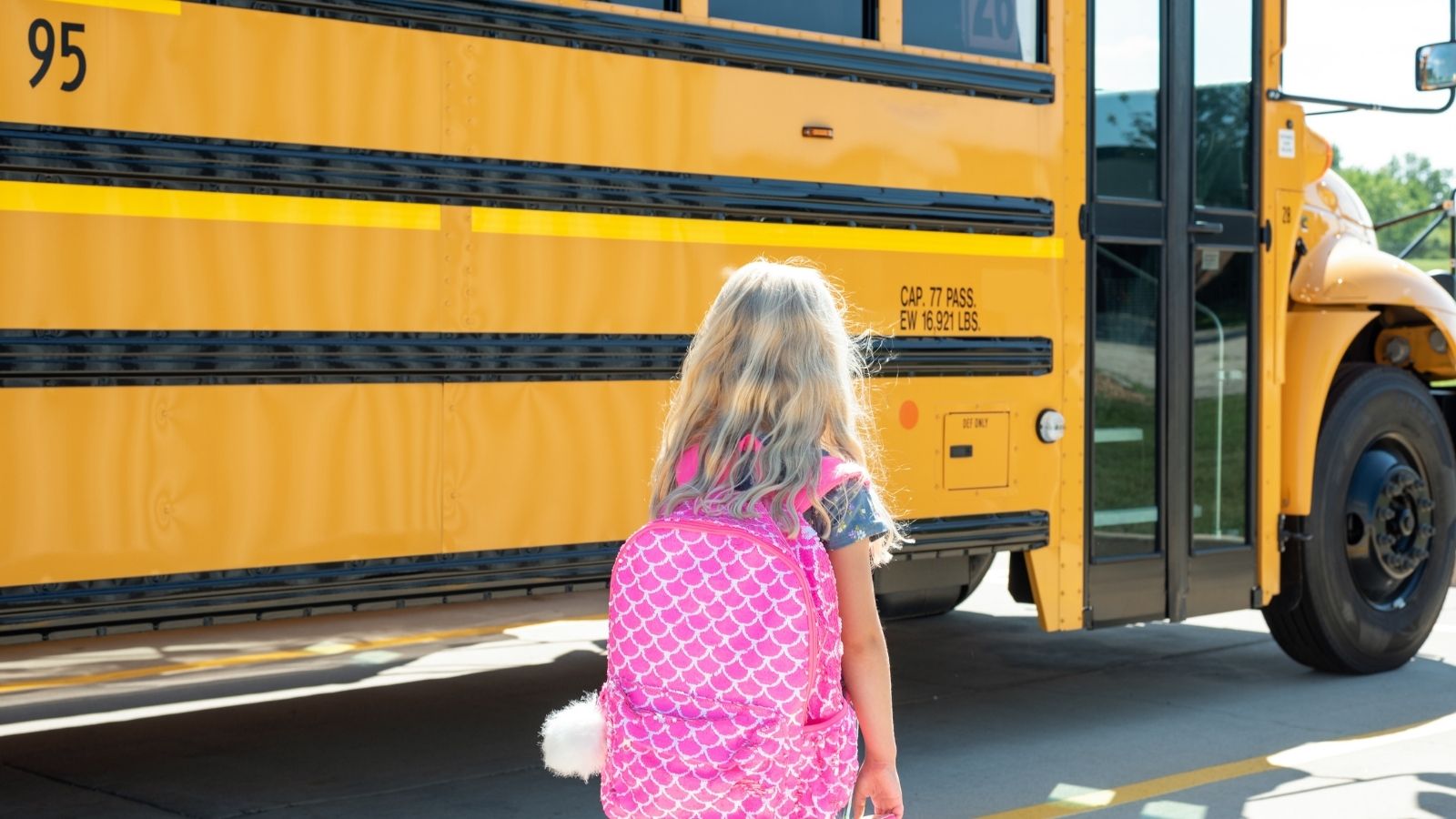 A Neighbors Van Nearly Hit Her Daughter in the Street—So She Took the Warning Straight to Facebook. little girl standing next to a school bus