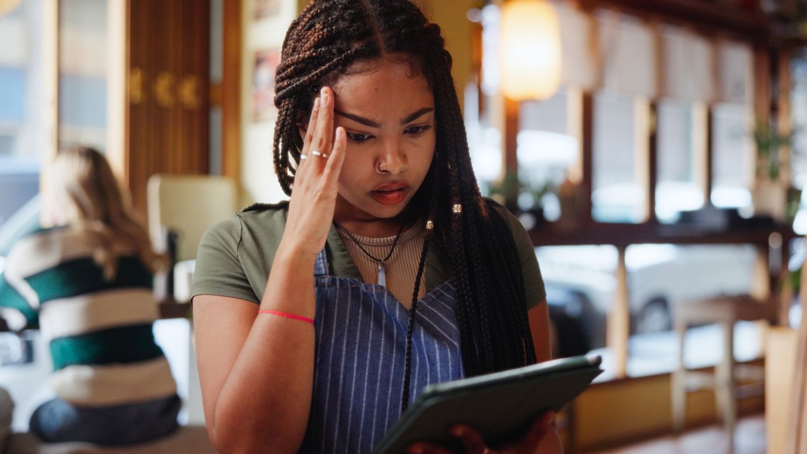 She Was Thrilled Over a Huge Tip—Until Her Manager Claimed the Table Was Hers and Kept the Money upset waitress looking at a tablet