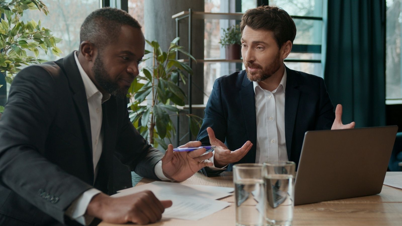 Employee Realizes A Big Problem With The Companys Overtime Changes, So He Points Out The Impact To A Manager And Gets The Changes Reversed two businessmen talking and looking at a computer