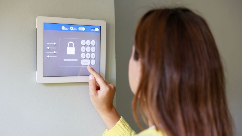 woman entering the pin code for her home security system