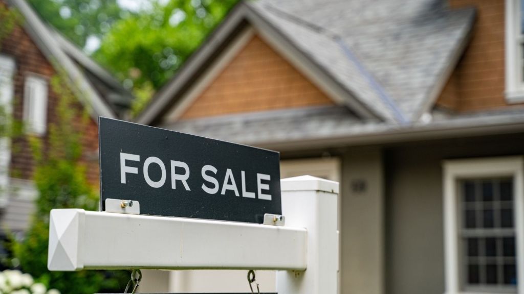 for sale sign in front of a house