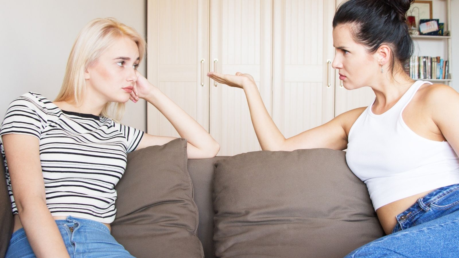 Their Financial Situations Arent Close to Equal. Her Friend Still Treats Every Declined Expense as Freeloading two female friends sitting on a couch arguing