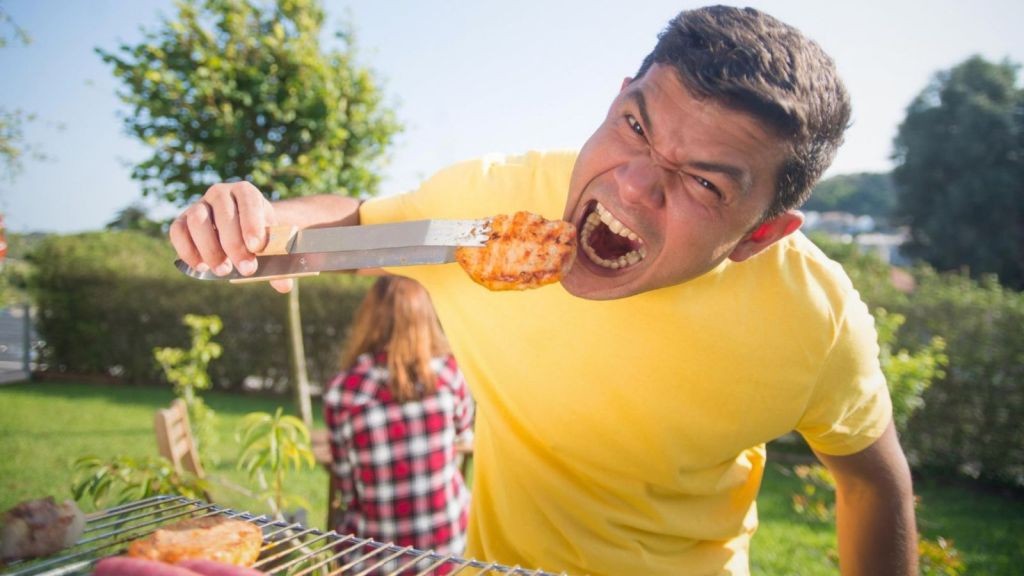 Man eating stake outside