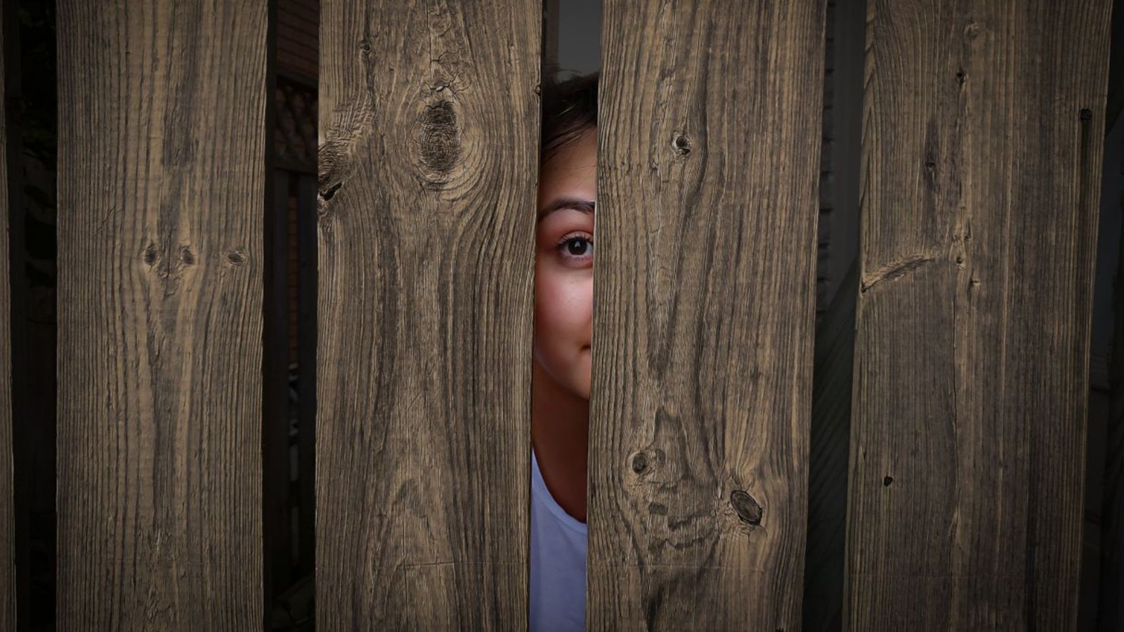 Woman peeping through fence