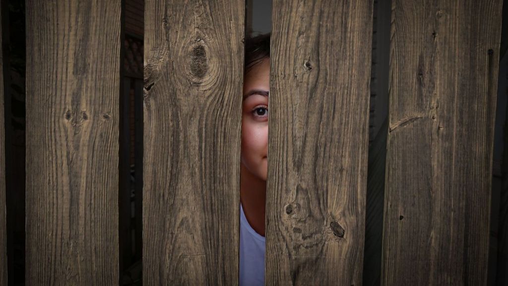 Woman peeping through fence