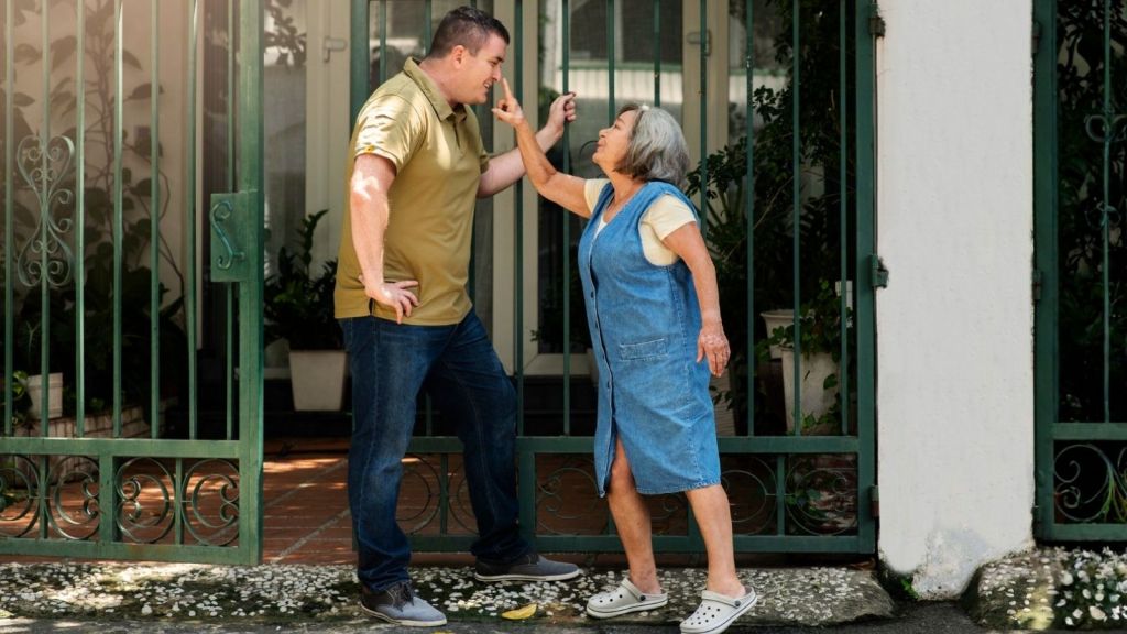 Woman pointing at man at gates