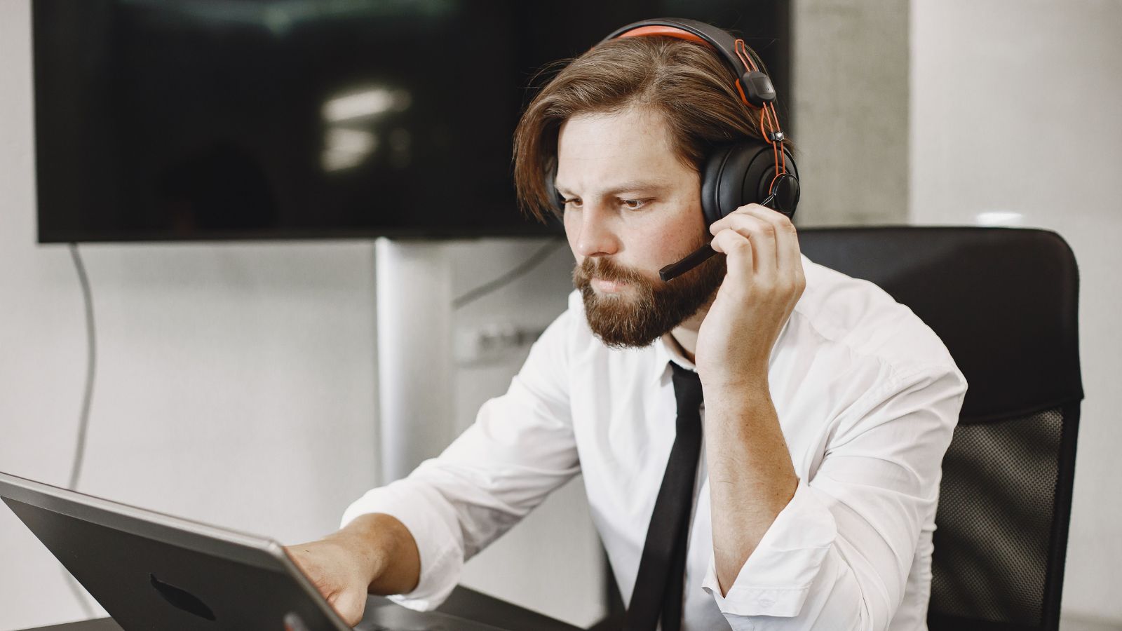 man in white shirt working on a laptop