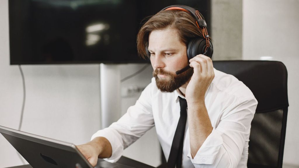 man in white shirt working on a laptop