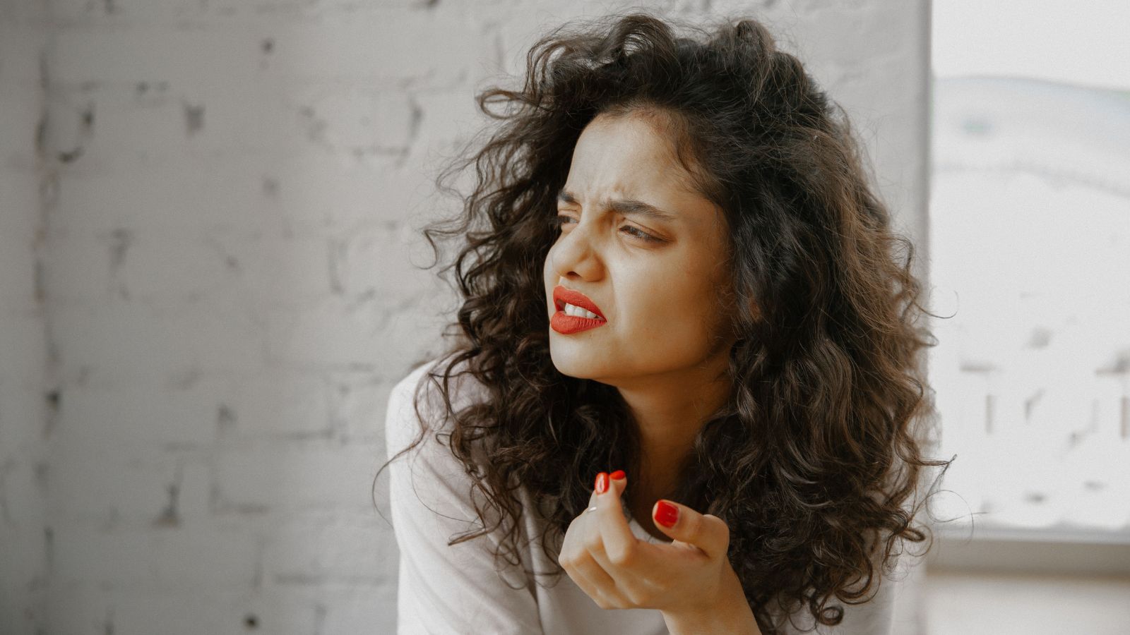 A Man Publicly Lectured a Woman About Her Choice of Feminine Hygiene Products—Until Another Woman Stepped In and Shut Him Down in Front of Everyone Woman with curly hair looking confused
