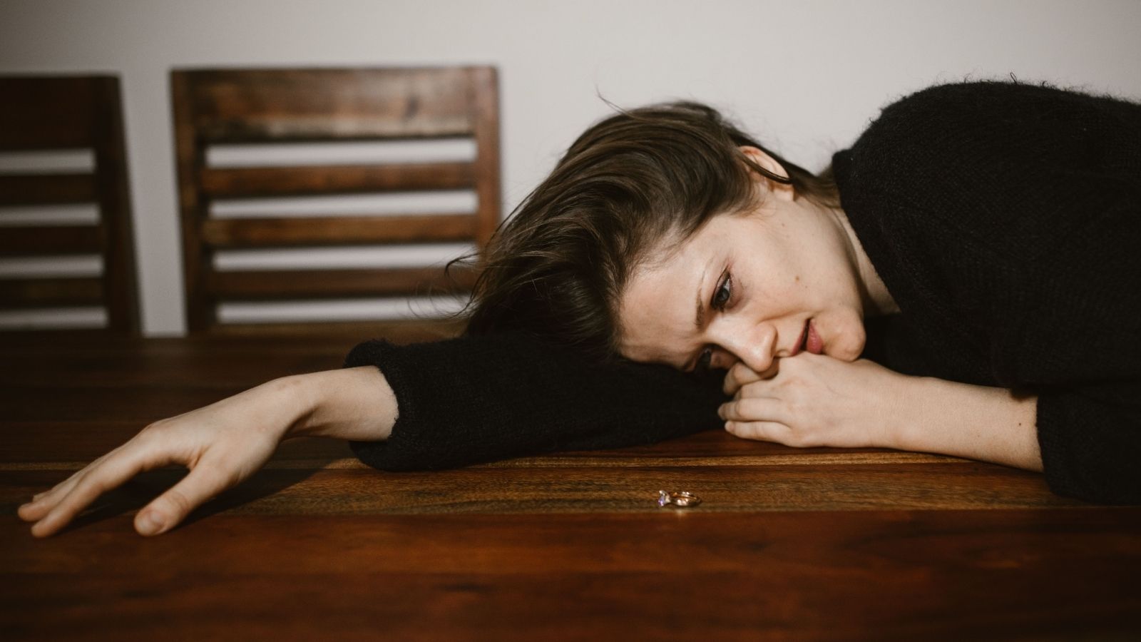 Depressed woman sprawled out on table