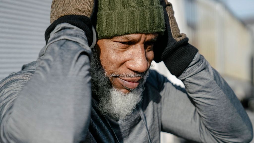 Man covering his ears outside