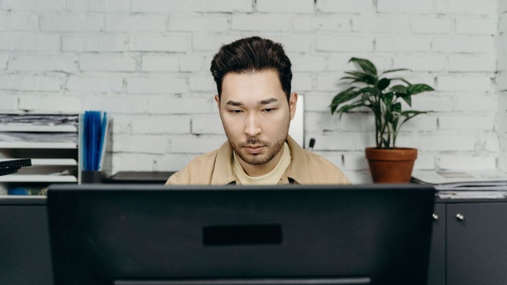 Man staring blankly at computer monitor
