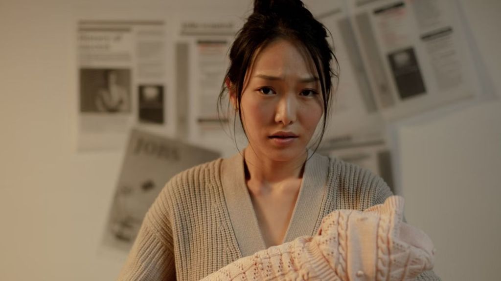 Woman with a worried face carrying her baby wrapped in a blanket