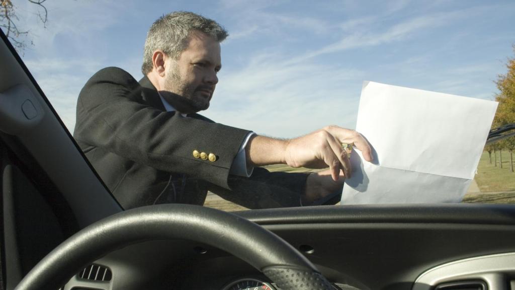 man leaving a note on a car