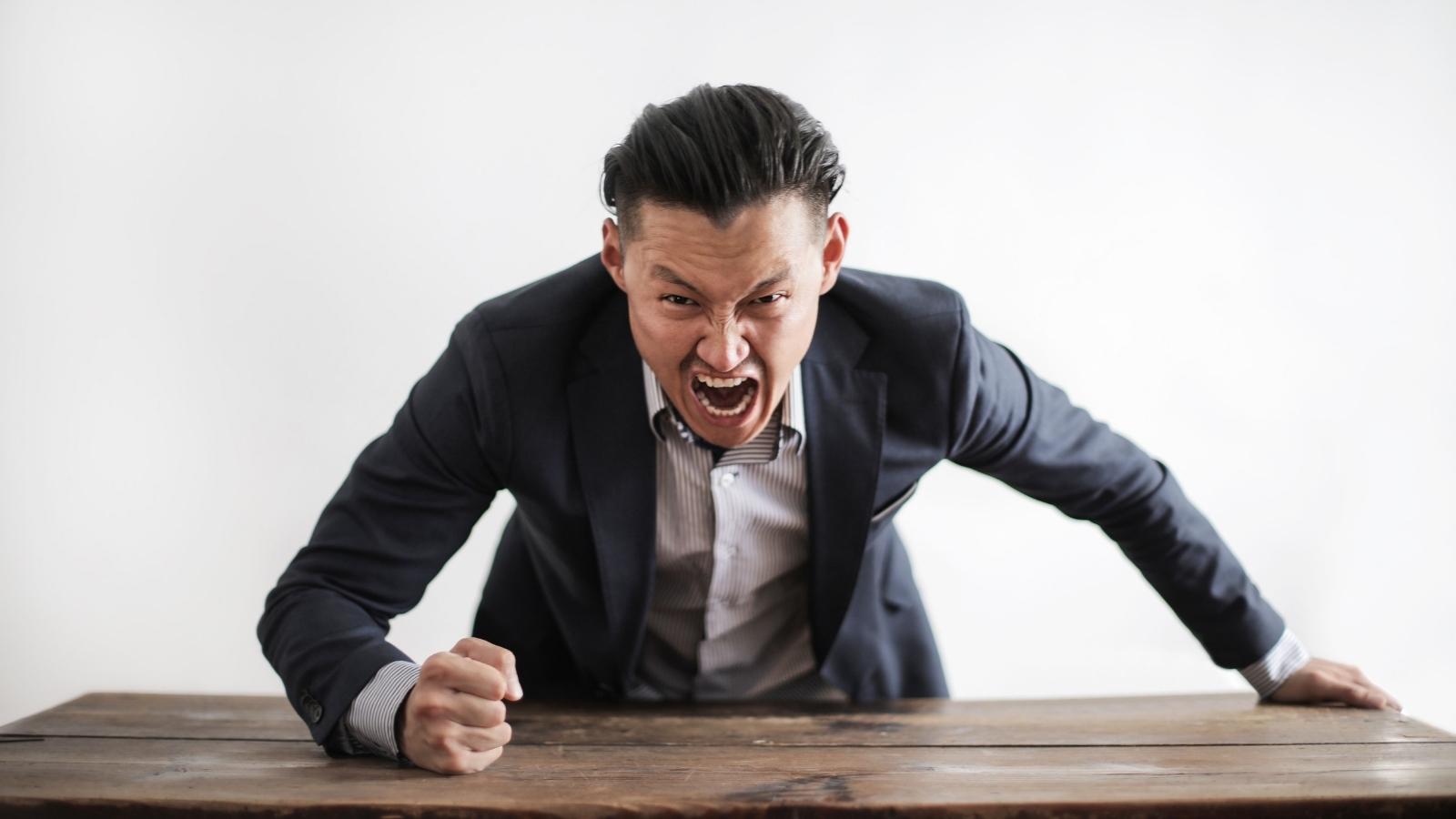 She Just Wanted to Keep the Hotel Cool—Then an Outraged Guest Accused Her of Causing Global Warming angry man pounding fist on the desk
