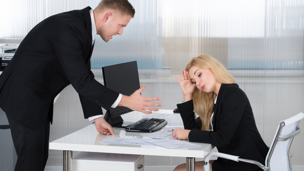 boss talking to frustrated female employee at work